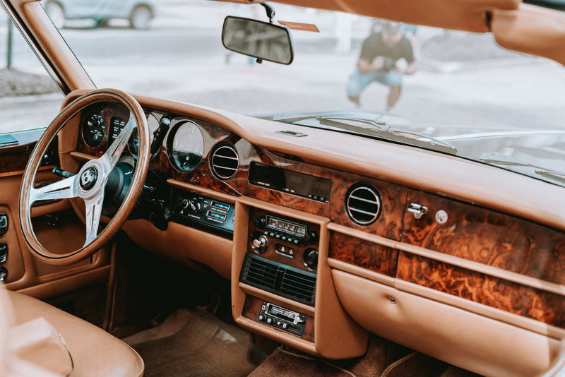 Mauvaise odeur dans la voiture : habitacle soigné avec tableau de bord en bois et cuir, prêt à recevoir un diffuseur de parfum PURRA