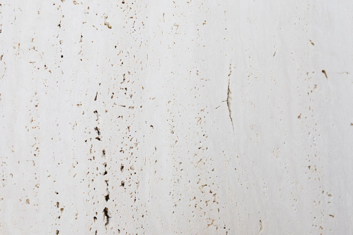 Mur de travertin clair, matière minérale choisie pour illustrer comment régler un diffuseur de parfum sans application